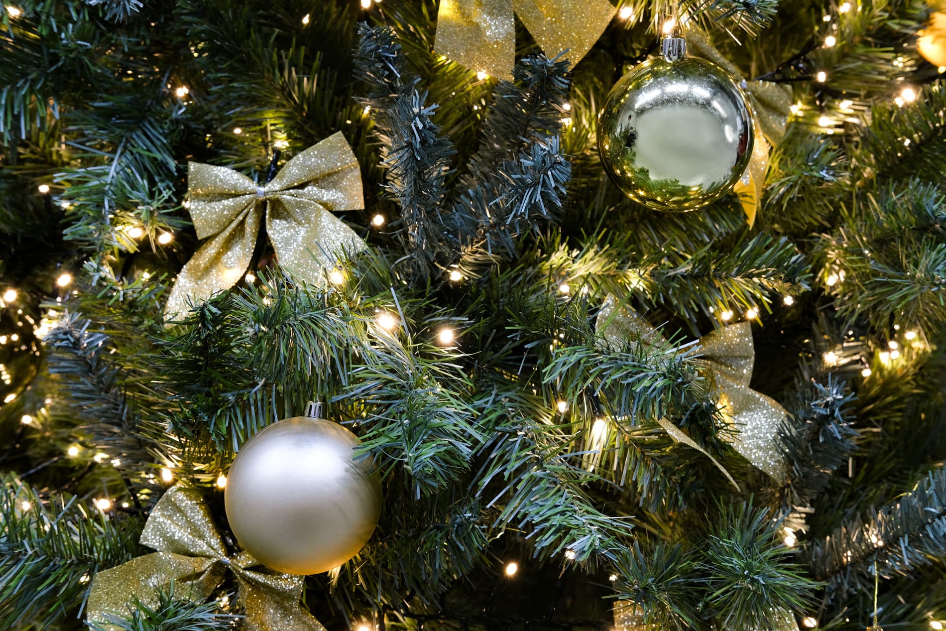 Sapin artificiel décoré selon le thème Or et Nœuds
